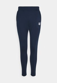 Tmavě modré úzké teplákové kalhoty s hladkou texturou, vybavené pružným páskem a vyšitým bílým logem na levém stehně.