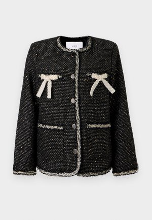 Schwarze Tweedjacke mit weißem Besatz, zwei Vorderseiten-Taschen und Schleifendetails an den Taschen, mit Rundhalsausschnitt und fünf Knöpfen auf der Vorderseite.