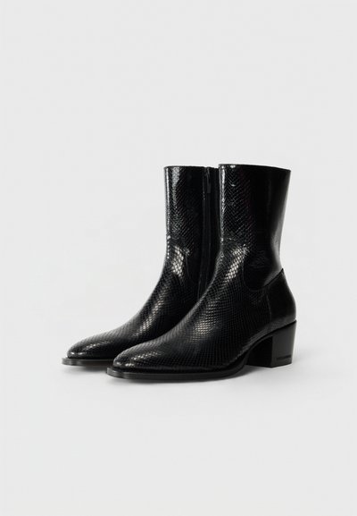 Botas negras hasta el tobillo con textura de piel de serpiente, punta afilada y cremallera lateral. Tacón ligeramente robusto. Superficie lisa y diseño elegante.
