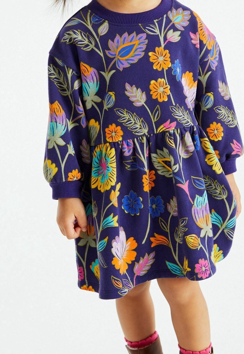 Robe d'enfant bleu marine avec un imprimé floral coloré, manches longues, col rond et une taille froncée avec une jupe évasée.