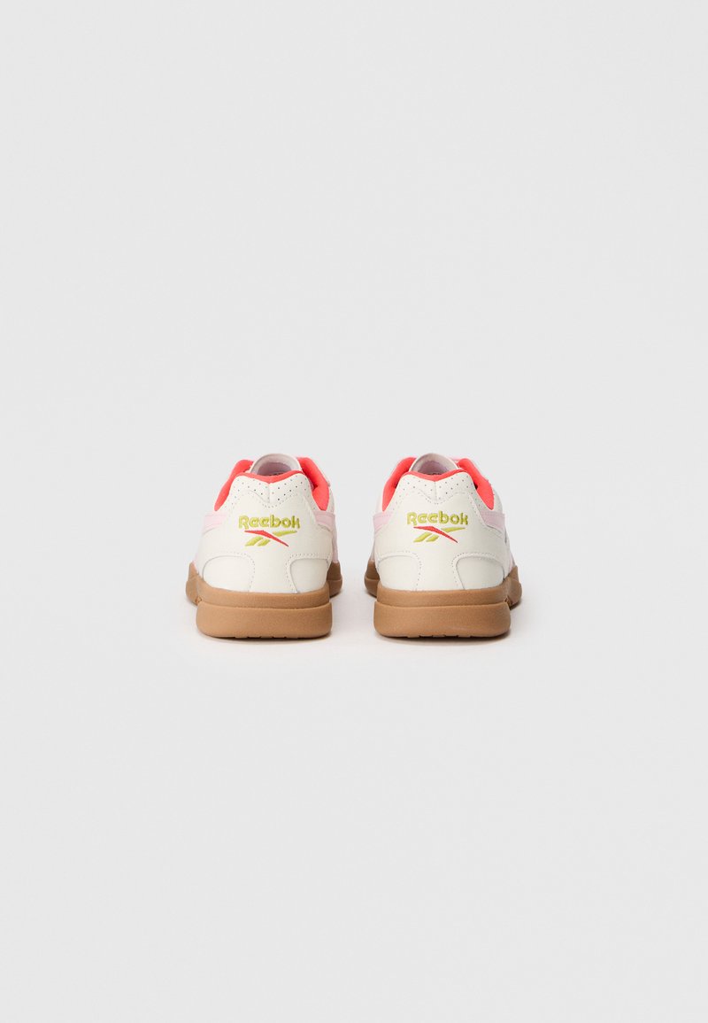 Scarpe da ginnastica bianche con dettagli rosa, parte superiore in materiale sintetico, collare imbottito e suole in gomma testurizzata. Logo Reebok sul tallone.