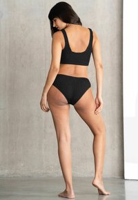 Bralette de punto acanalado negro y braguita de bikini de talle alto, con tirantes anchos y espalda en forma de U, con un diseño minimalista y sin costuras.