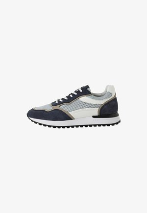 Zapatillas de hombre con parte superior de malla en gris, acentuadas con gamuza azul marino y beige. Cuenta con una entresuela blanca y una suela exterior de goma negra.
