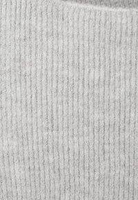 Tela de punto acanalado gris claro con una superficie suave y texturizada, que presenta rayas verticales y un aspecto acogedor.