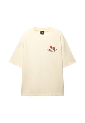 Cremefarvet oversized t-shirt lavet af blød bomuld; har grafisk blomsterdesign i rød og sort tekst på venstre side. Korte ærmer, rund hals.
