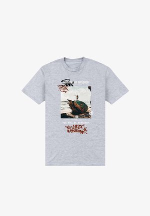 T-shirt en coton gris avec un imprimé graphique représentant une photo d'une personne sur une planche de surf colorée et un texte stylisé en différentes couleurs.