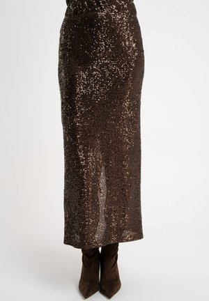 Brązowa spódnica midi z cekinami, o dopasowanym kroju i elastycznym pasku, zestawiona z brązowymi, spiczastymi botkami. Gładka tekstura z błyszczącymi akcentami.