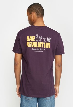Paarse katoen t-shirt met op de achterkant een grafische print met de tekst "BAR REVOLUTION" en iconen van een fles, glazen en een trommel.