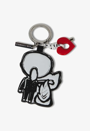 Juodai balta guma raktų pakabukas, vaizduojantis personažą, laikantį baltą daiktą, su raudonu širdelės pakabuku ir sidabriniu apvaliu raktų žiedu.