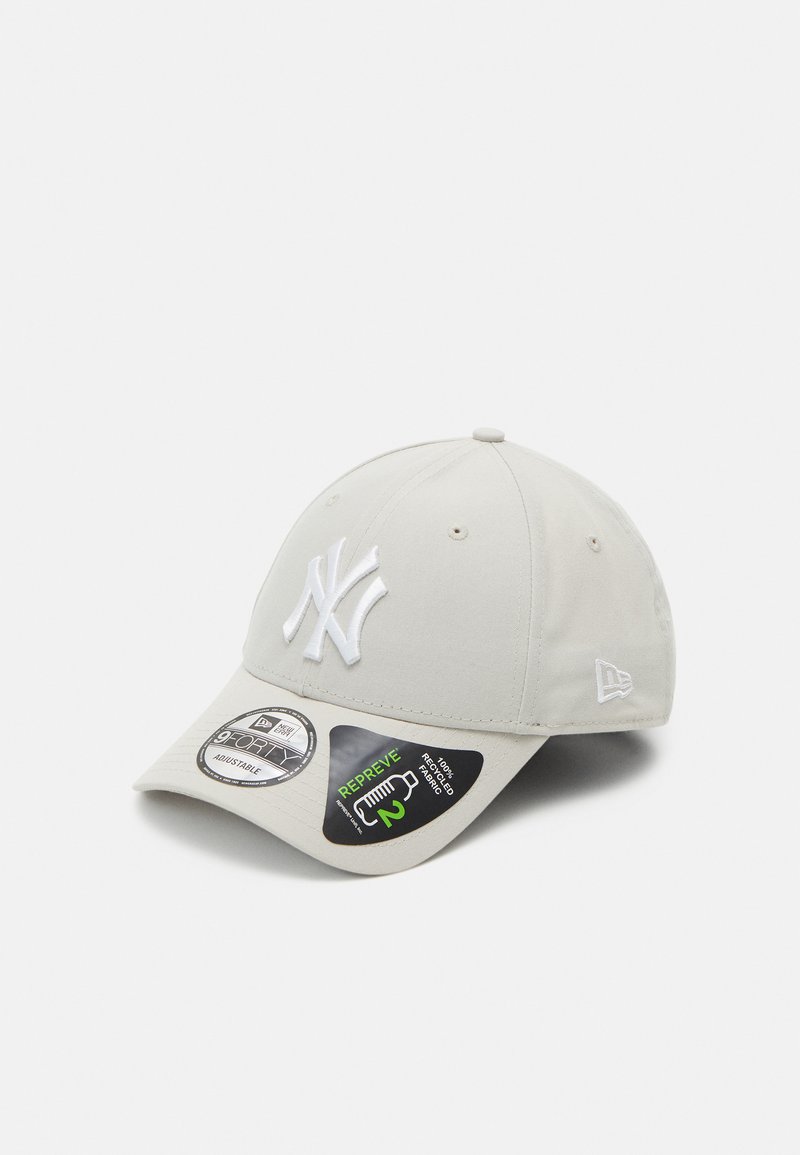 Lys grå baseballcap laget av stoff, med en hvit brodert logo foran, justerbar stropp og buet skjerm.