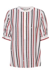 Blusa bianca con strisce verticali rosse e nere e pois, caratterizzata da un colletto rotondo e bottoni sulla parte anteriore. Maniche corte a sbuffo.