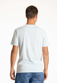 Himmelblaues Kurzarm-T-Shirt mit Rundhalsausschnitt, aus Baumwolle, mit glatter Textur, figurbetonter Form und schlichtem Design.