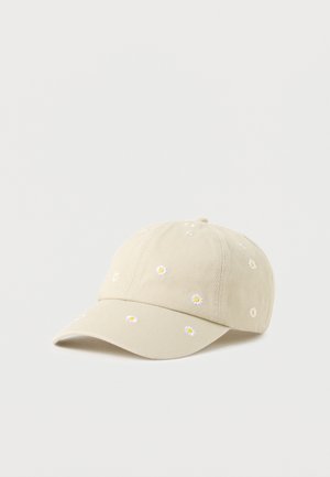 Beige baseball cap with small embroidered white daisies scattered across the fabric, resting on a plain light background.