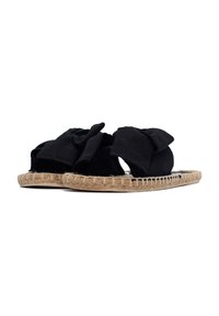 Sandali piatti in tessuto nero con un grande fiocco sulla parte superiore, dotati di una suola in juta e un bordo intrecciato. Il design è piatto con un'apertura sulla punta.