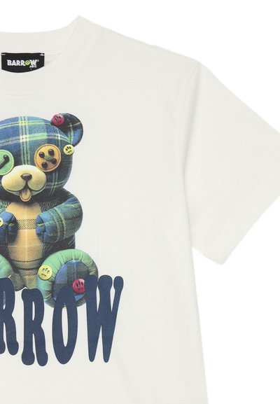 T-shirt bianco a maniche corte con un grafico colorato di un orsetto di peluche con bottoni, e un testo azzurro in grassetto che recita "BARROW" sotto il design.