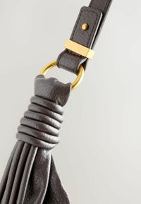 Mørkegrå lædertaske rem med samlet tekstur, guldfarvet hardware og en cirkulær ringbeslag. Slående intrikate stikninger.