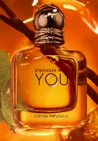 Przezroczysta szklana butelka perfum z okrągłą srebrną zakrętką, wypełniona bursztynowym płynem. Etykieta brzmi "STRONGER WITH YOU" oraz "EMPORIO ARMANI."