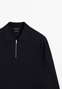 Navy pullover with a zip collar. Made from merino wool. Features a smooth texture and minimalistic design with a subtle sheen.