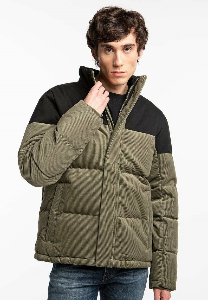 Padded jacket w oliwkowego kordurowego materiału z czarną górną częścią. Posiada wysoki kołnierz, zamek błyskawiczny i obszerne boczne kieszenie.