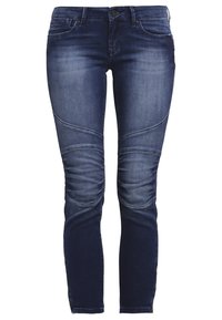 Mörkblå jeans med slim fit, med en blekt textur och unika paneler som är sydda runt knäna. Fyra fickor och dragkedja.