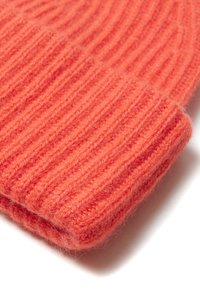 Beanie lavorato a maglia in un vivace corallo, realizzato in morbida lana, con una texture a costine e un risvolto piegato per maggiore calore e stile.