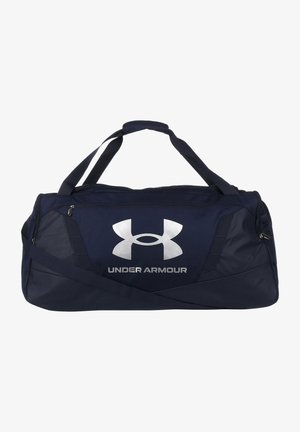 Sac de sport navy en tissu durable avec un grand logo argenté, des sangles réglables et un compartiment zippé pour le rangement.