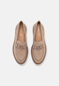 Beige Lederloafers mit einem dekorativen Ketten-Detail, runder Zehenform, kontrastierendem Nähten und einer flachen Sohle. Markenname "Caprice" ist innen sichtbar.