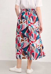 Jupe maxi avec une taille élastique, motif géométrique vivant en rose, turquoise, marron et blanc, dotée d'un tissu fluide et ample.