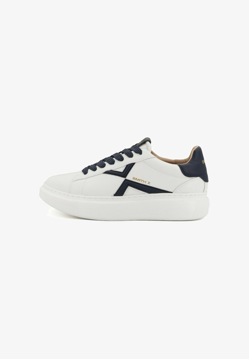 Sneakers sportive bianche con accenti navy, lacci piatti, suola texturizzata e dettagli del logo sul lato e sul tallone. Materiale in pelle liscia.