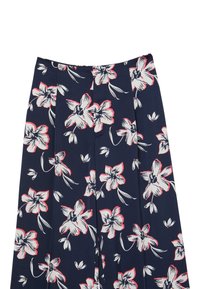 Pantalon en tissu bleu marine avec un motif floral comportant des fleurs blanches et roses, des plis et une texture lisse.