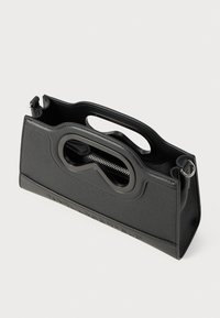 Borsa a tracolla in pelle nera con finitura testurizzata, doppio manico e un design con ritagli unico. Presenta un comparto con zip per una conservazione sicura.