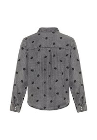 Cămașă din denim gri cu mâneci lungi, platcă la spate și broderie neagră cu model de frunze. Are manșete cu nasturi și tiv curbat.