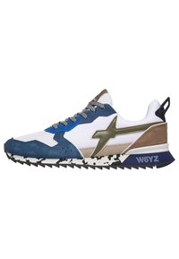 Zapatilla multicolor con acentos de ante en blanco, azul y marrón, un logo verde, suela texturizada y patrón de tracción rugoso en negro.