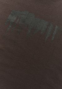 Sötétbarna szövet, az élén egy texturált, absztrakt fekete árnyalatmintával. A felület lágy és sima, finom fényességgel.