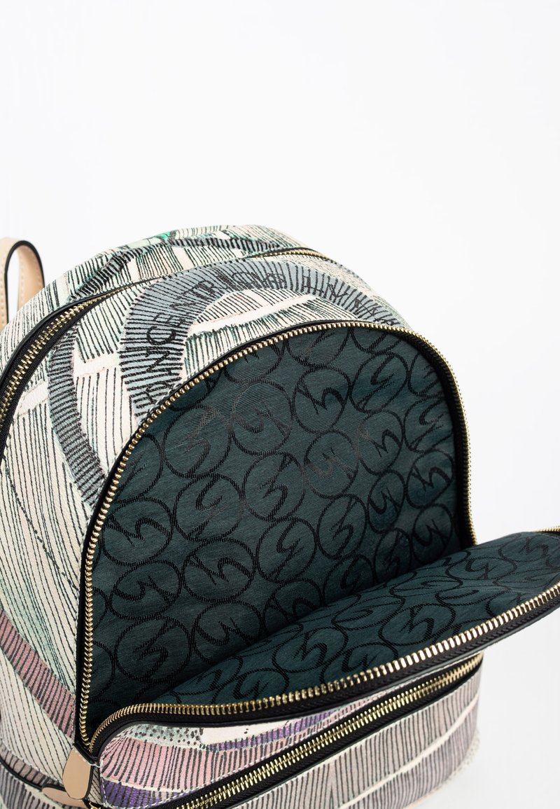 Mochila con un exterior de tela estampada en blanco roto y verde, con cremalleras doradas y un interior forrado en verde oscuro con un patrón de logo.