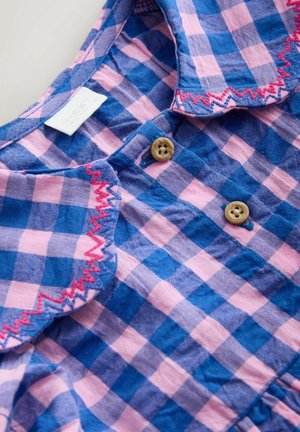 Pleds krekls zilganās un rozīgās krāsās ar apkakli, kurai ir zigzaga šuvums, divām brūnām pogām un auduma etiķeti.