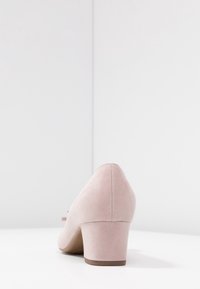 Talons en suede rose clair, bout arrondi, talon bloc de hauteur intermédiaire, texture lisse et léger accent de nœud sur le côté avec une finition unie.