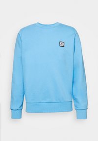 Světle modrá mikina vyrobená z bavlny, s kulatým výstřihem, dlouhými rukávy a malou černou nášivkou s logem Diesel na hrudi.