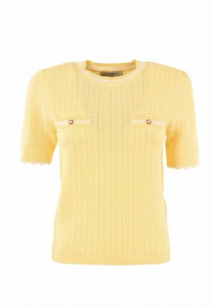 Pull en tricot jaune à manches courtes avec un motif texturé, un col rond, des bords de manches festonnés et deux petits boutons décoratifs sur la poitrine.