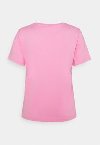 Růžové tričko s krátkým rukávem a kulatým výstřihem, rovného střihu. Měkký, hladký bavlněný materiál s minimálními detaily na zádech.