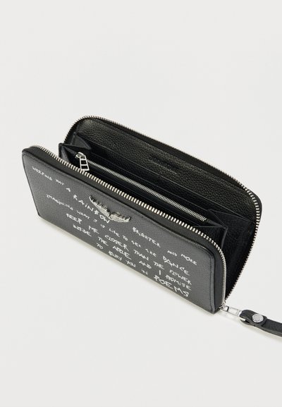 Portefeuille noir en cuir avec fermeture éclair sur tout le tour, texte manuscrit blanc sur le devant et une lanière pour le poignet, montré partiellement ouvert.