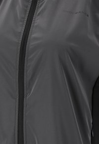 Grau Sportjacke mit glatter, glänzender Textur, Frontreißverschluss und schwarzen Akzenten. Mit dezent aufgedrucktem Markennamen "ENDURANCE".
