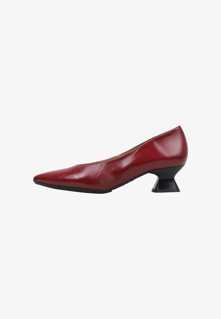 Escarpin en cuir rouge avec un bout pointu et un talon sculpté noir unique. Texture lisse, design épuré et style minimaliste.
