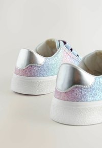 Baskets argentées et pastel avec surface pailletée, semelles en caoutchouc et accents métalliques au talon. Design à lacets avec cols rembourrés.