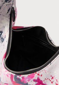 Λειτουργική τσάντα με πολύχρωμο, αφηρημένο σχέδιο σε ροζ, γκρι και λευκό. Διαθέτει μαύρο εσωτερικό και κλείσιμο με φερμουάρ.
