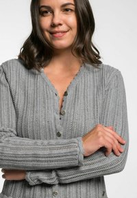 Hellgrauer gestrickter Cardigan mit vertikaler Rippstruktur, gewelltem Saum und fünf dekorativen Knöpfen. Weicher Stoff und lockere Passform.
