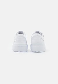 Vita lädersneakers med en slät yta, rundad design, vadderad krage och en tjock gummisula med subtila mönster.