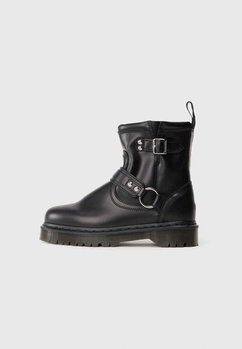 Botte noire en cuir mi-mollet avec semelle épaisse, deux sangles réglables avec boucles argentées et une languette à l'arrière.