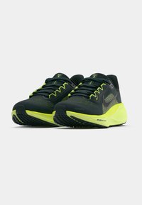 Ζεύγος μαύρων και φθορίζοντος πράσινου Nike Air Zoom αθλητικών παπουτσιών, γυρισμένο για να δείξει λεπτομέρειες μπροστινής και πλάγιας πλευράς.