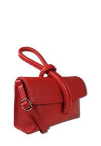 Red leather handbag with a textured surface, featuring a flap closure and a loop handle, accented by an adjustable shoulder strap.